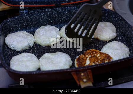 Fry cheese cakes at home in a pan Stock Photo