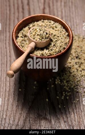 Organic shelled hemp seeds in a bowl on wooden background. Copy space. Closeup. Stock Photo