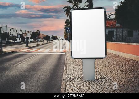 A template of an empty vertical advert banner on the paving-stone; the mockup of a blank advertising poster in suburban settings; a mock-up of a white Stock Photo