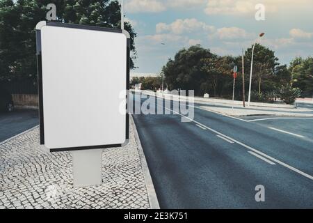 A mockup of a blank vertical ad banner on the paving-stone; the template of an empty advertising poster in suburban settings; a mock-up of a white inf Stock Photo