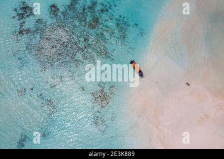 Aerial shot of the white sand sandbanks washed with turquoise Indian ocean waves near the Zanzibar island, Tanzania. Couple came here on the motor boa Stock Photo