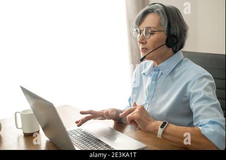 Mature female office worker typing on the laptop Stock Photo