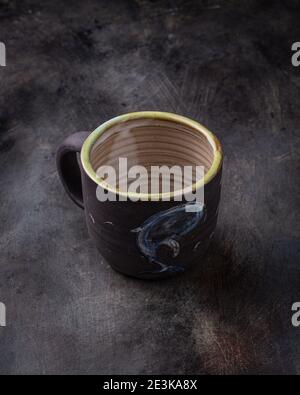 Handmade ceramic cup on dark stone backgroud, copy space. Stock Photo