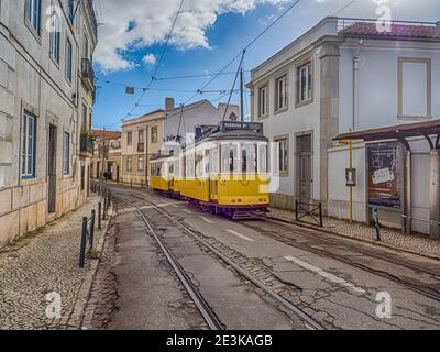 Classic Yellow Tram in Alfama,  the oldest neighborhood of Lisbon, Portugal, Europe. Stock Photo