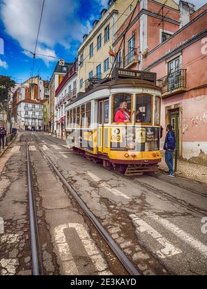 Classic Yellow Tram in Alfama,  the oldest neighborhood of Lisbon, Portugal, Europe. Stock Photo