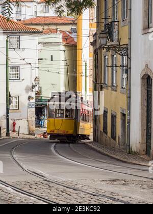 Classic Yellow Tram in Alfama,  the oldest neighborhood of Lisbon, Portugal, Europe. Stock Photo