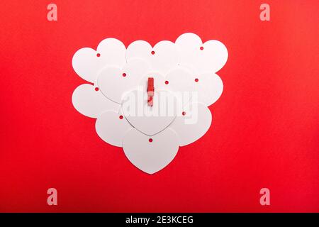 A heart made by blank heart shape cards on a red background. When you have so much to write to your love and a simple card is not enough. For Valentin Stock Photo