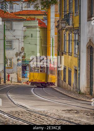 Classic Yellow Tram in Alfama,  the oldest neighborhood of Lisbon, Portugal, Europe. Stock Photo