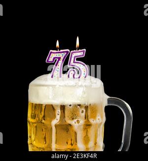 number 75 candles in beer mug for birthday celebration isolated on black Stock Photo