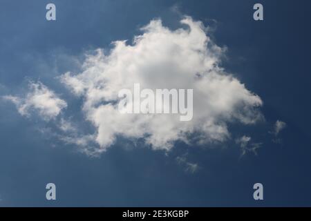 Fluffy white cumulus cloud in a blue summer sky Stock Photo