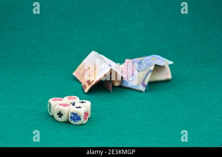 Close-up of some gambling dice where large amounts of money are bet on a green tablecloth and with copy space Stock Photo