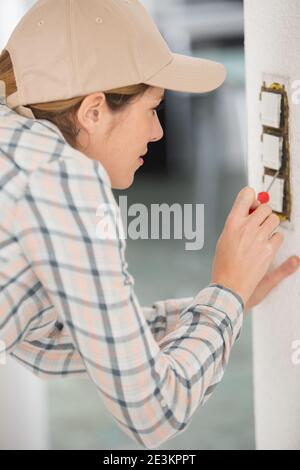 female electrician testing a wall socket Stock Photo