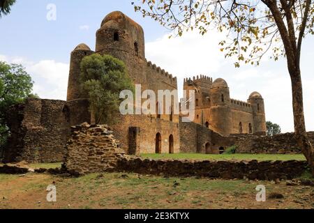 The Iyasu and Failedes palaces rise towards a blue sky above the crumbling courtyard walls in Gonder, Ethiopia, considered the Camelot of Africa. Stock Photo