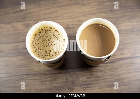 Macchiato and latte in carry out cups on a wooden table Stock Photo