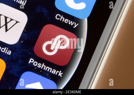 The Poshmark app icon is seen on an iPhone. Poshmark is a social commerce marketplace where people can trade new or used clothing, shoes, and accessories. Stock Photo