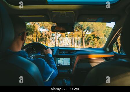 Young man driving Toyota car at sunset. Lisbon, Portugal. 15.01.2021 Stock Photo