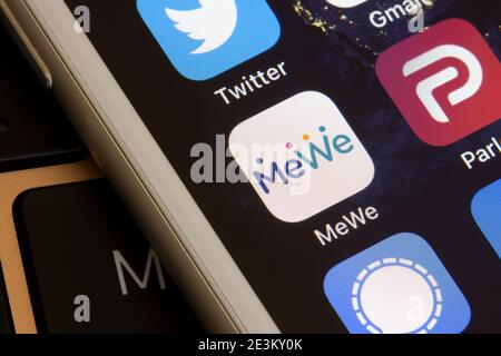 The MeWe mobile app icon is seen on an iPhone. MeWe is an American alt-tech social media and social networking service owned by Sgrouples. Stock Photo