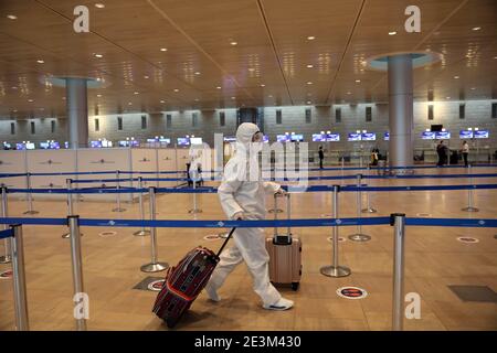 (210120) -- TEL AVIV, Jan. 20, 2021 (Xinhua) -- A passenger wearing a protective suit and mask walks at Ben Gurion International Airport near Tel Aviv, Israel, Jan. 19, 2021. Israel's cabinet decided on Tuesday to extend by 10 days a weeks-long nationwide lockdown to curb the spread of the COVID-19 pandemic. The ministers voted in favor of extending the tight lockdown until Jan. 31, according to a cabinet statement. The cabinet also decided that travelers entering the country will be required to present a negative coronavirus test taken within 72 hours before their flight. (Gideon Marko Stock Photo