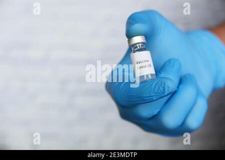 hand in gloves holding coronavirus vaccine, with copy space  Stock Photo