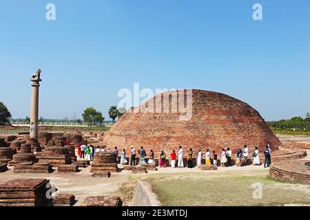 9th March 2020, Kolhua ,Vaishali, Bihar, India.  Ananda Stupa with an Asokan pillar. Devotees circumventing the stupa. Relic Stupa which encases one o Stock Photo