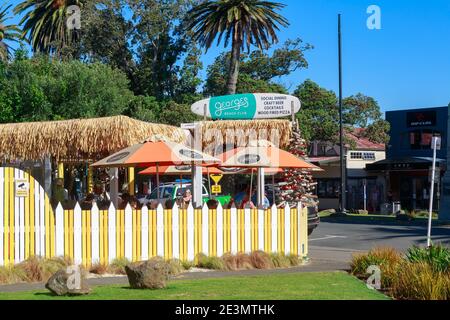 George's Beach Club, a restaurant in Raglan, New Zealand. It has a surfboard for a sign and a Christmas tree made out of driftwood Stock Photo