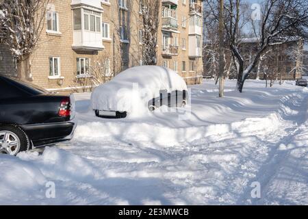 Car on a street covered with a lot of snow after massive snowstorm Stock Photo