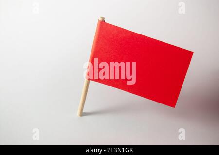 Miniature blank red flag. Ready for a Message. Paper flag Isolated on white background. Stock Photo