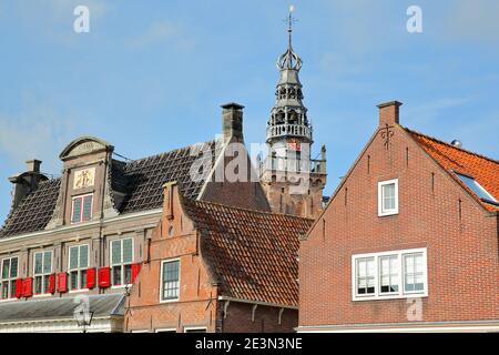 Close-up on historic house facades in Monnickendam, North Holland, Netherlands, with the spire and clock tower of Speeltoren (Carillon) in background Stock Photo