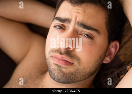 Closeup portrait of unshaven young guy in a hammock, looking at camera Stock Photo