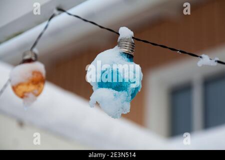 colored lights that have become snow covered are controlled by sunlight Stock Photo