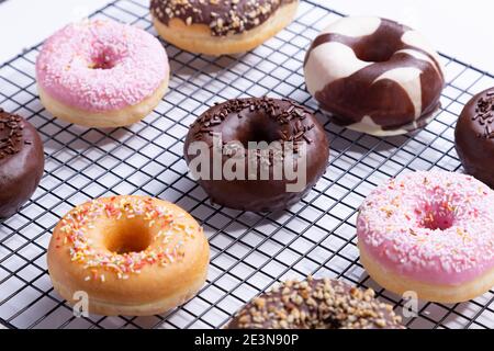 Mixed donuts on grid, on white background. Stock Photo