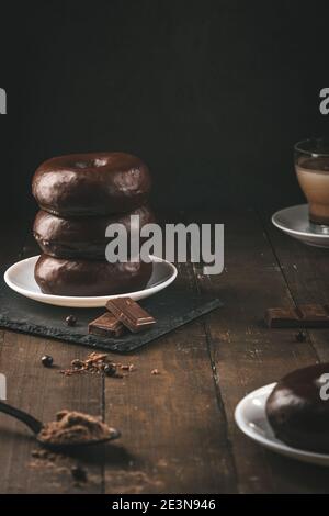 Stack of chocolate donuts on dark background. Vertical format. Stock Photo