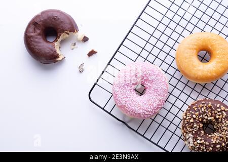 Flat lay composition of mixed donuts on white background. Stock Photo
