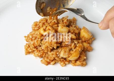 Serving rice paella with cuttlefish Stock Photo
