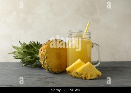 Jar of pineapple juice with pineapple slices on a wooden table, a refreshing pineapple juice in a rustic setting Stock Photo