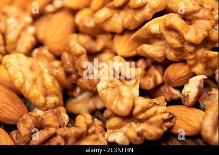 Almonds and walnuts scattered on the table. Close-up, selective focus Stock Photo