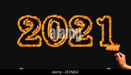 Hand Burning 2021 Number with fire flame. Burned 2021 black background concept Stock Photo