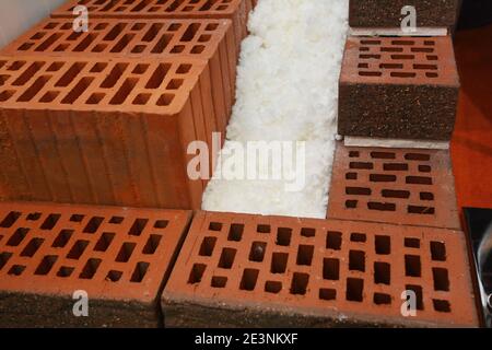 A close-up of cross-section of an unfinished energy efficient, thermal insulated house wall built from porous ceramic blocks and polystyrene. Stock Photo