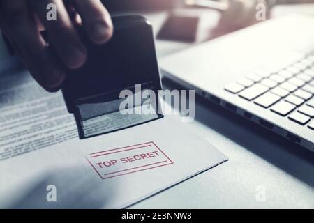 hand put a top secret stamp on document. confidential information concept Stock Photo