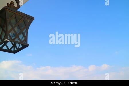 Black vintage lamp against bright blue sky Stock Photo