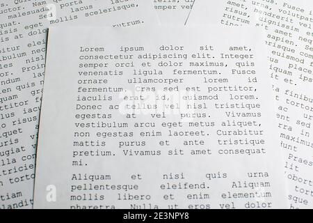 lorem ipsum dolor sit amet concept. selective focus photo of paper sheets with publishing and graphic design placeholder text on them. Stock Photo