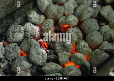 Burnt charcoal bricks ready to cook, summer barbecue. Selective focus Stock Photo