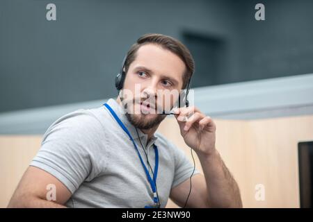 Man with headphones listening and speaking into microphone Stock Photo