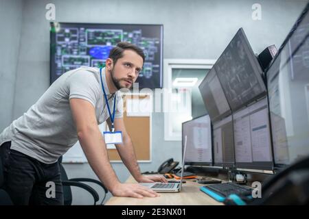 Serious man watching monitors at work Stock Photo