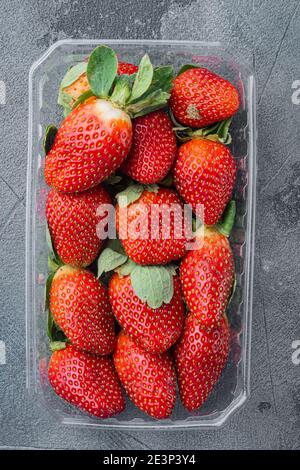 Transparent plastic tray, with freshly picked strawberries, on gray background, top view flat lay Stock Photo