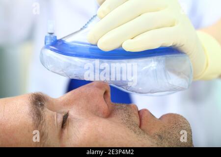 Anesthesiologist gives a respiratory anesthesia to a patient before surgery. Stock Photo