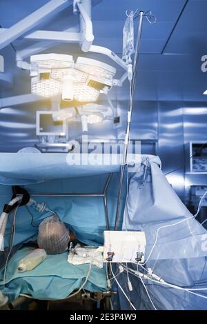 Sleeping patient on the operating table in the advanced surgery room. Stock Photo