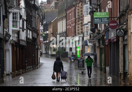 People walk up and down the High street in Winchester, Hampshire, as Storm Christoph is set to bring widespread flooding, gales and snow to parts of the UK. Heavy rain is expected to hit the UK, with the Met Office warning homes and businesses are likely to be flooded, causing damage to some buildings. Picture date: Wednesday January 20, 2021. Stock Photo