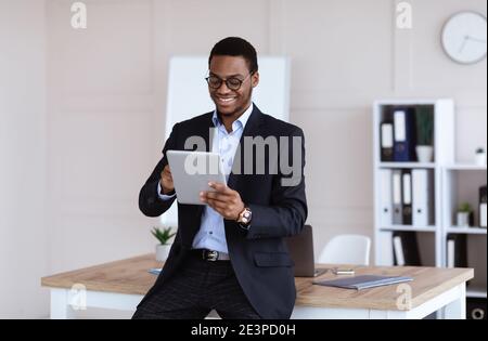 Joyful african american businessman using newest digital tablet Stock Photo