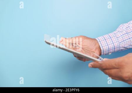 side view of businessman using digital tablet on blue background Stock Photo